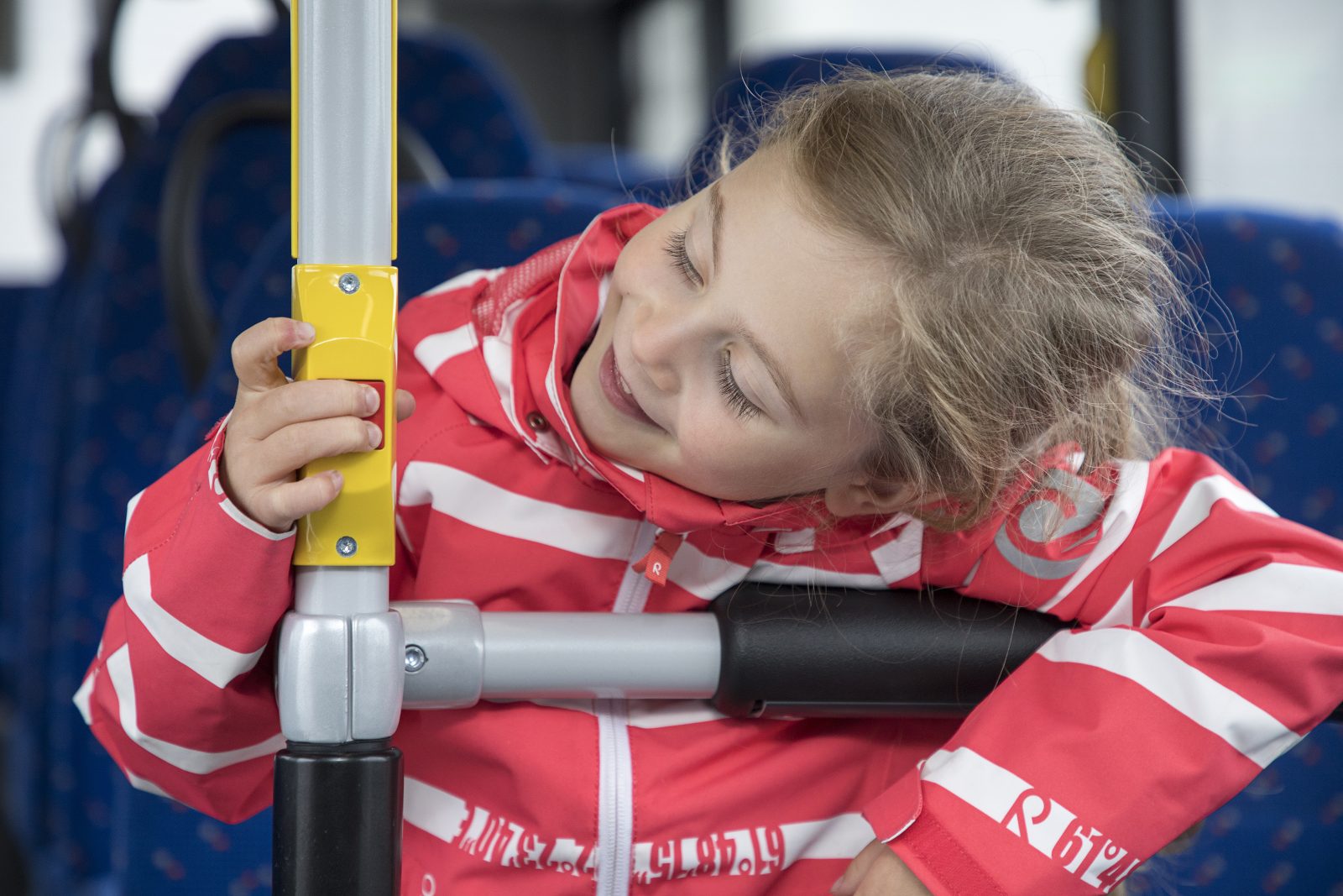 Lapsi istuu bussissa ja painaa stop-nappia.
