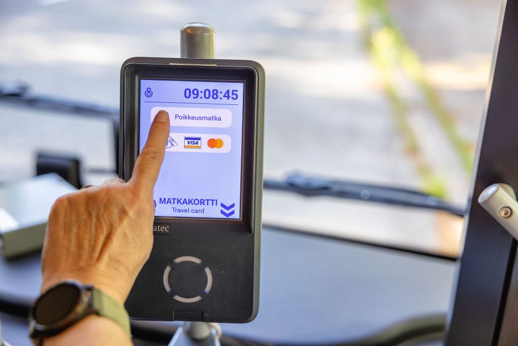 Matkustaja painaa poikkeusmatka painiketta lippulaitteesta.