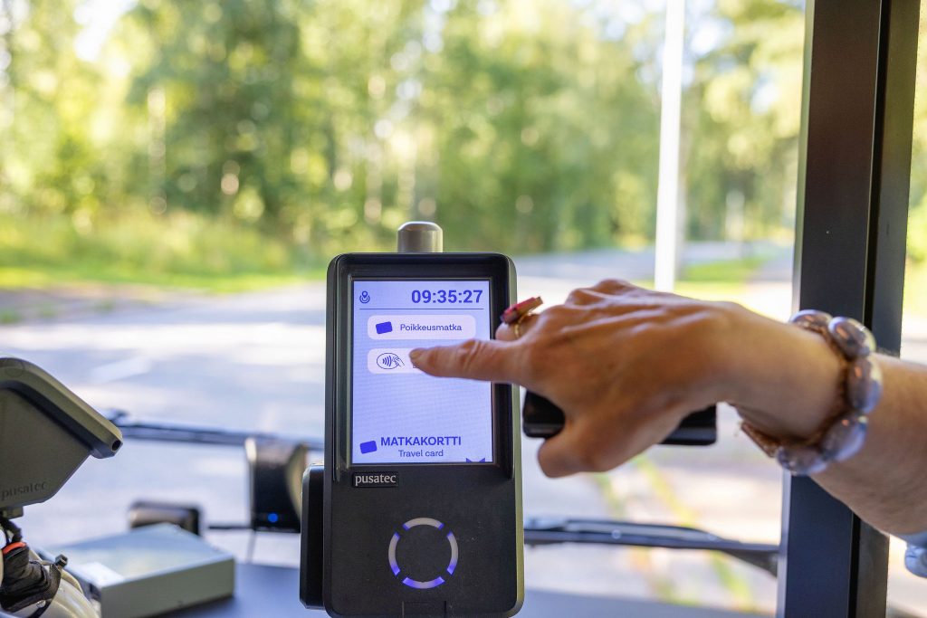 Asiakas painaa lippulaiteesta lähimaksu symbolia.