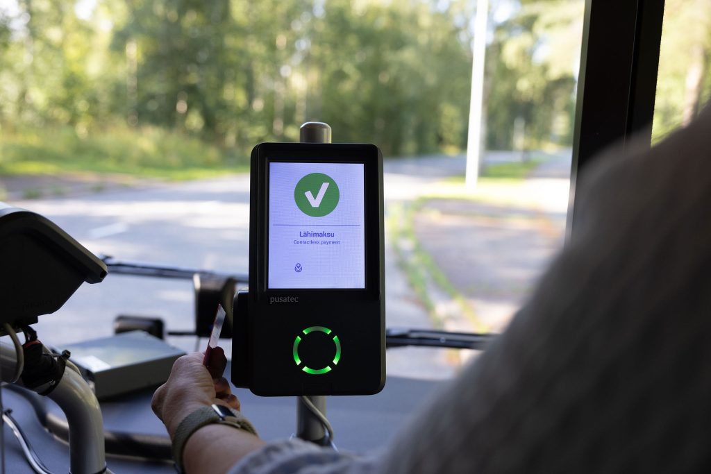 Matkustaja pitää pankkikorttia lippulaitteen etälukijan edessä.