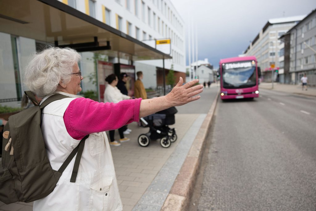 Seniorimatkustaja näyttää pysähtymismerkkiä bussille.